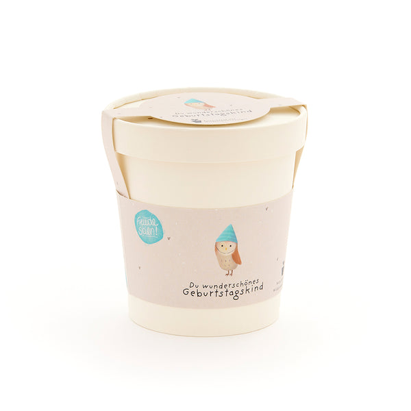 Beiger Becher mit Deckel und Etikett, darauf eine Eule mit blauem Hut und der Aufschrift „Du wunderschönes Geburtstagskind“.