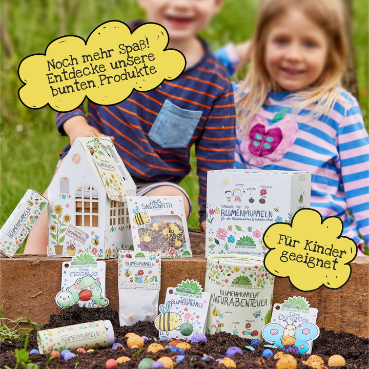 Zwei lächelnde Kinder mit bunten Samentüten im Garten, umgeben von Sprechblasen mit Text "Noch mehr Spaß! Entdecke unsere bunten Produkte" und "Für Kinder geeignet".
