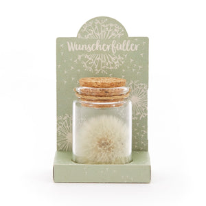Glasfläschchen mit Löwenzahn-Pusteblume und Korken, auf grünem Karton mit der Aufschrift "Wunscherfüller".