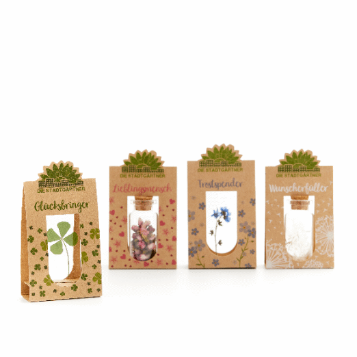 Vier kleine Geschenktüten mit Aufschriften "Glücksbringer", "Lieblingsmensch", "Trostspender", und "Wunscherfüller" jeweils mit verschiedenen Pflanzenmotiven.