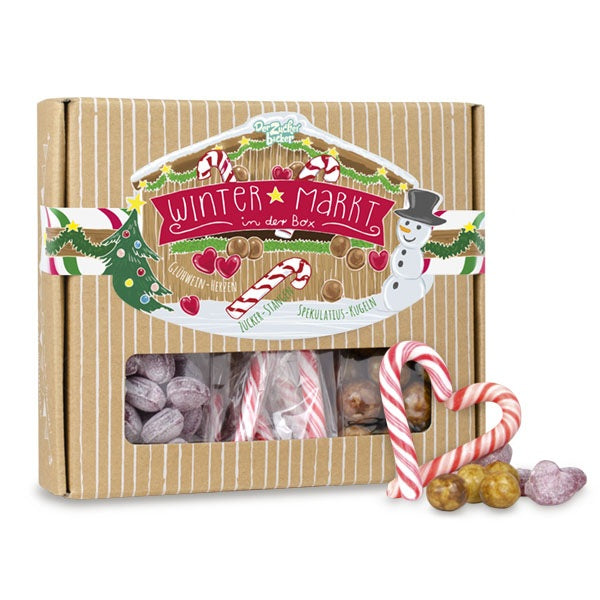Verpackung einer "Wintermarkt"-Geschenkbox mit Süßigkeiten und Weihnachtsdekorationen.