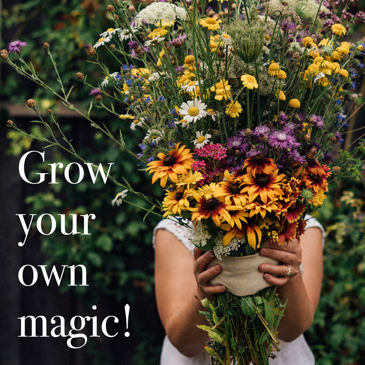 Person hält einen großen, bunten Blumenstrauß mit der Aufschrift "Grow your own magic!"