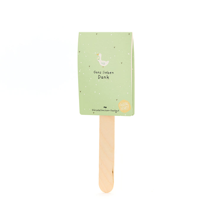 Ein grünes Kärtchen mit Gänse-Illustration und dem Text „Gans lieben Dank“ auf einem Holzstäbchen.