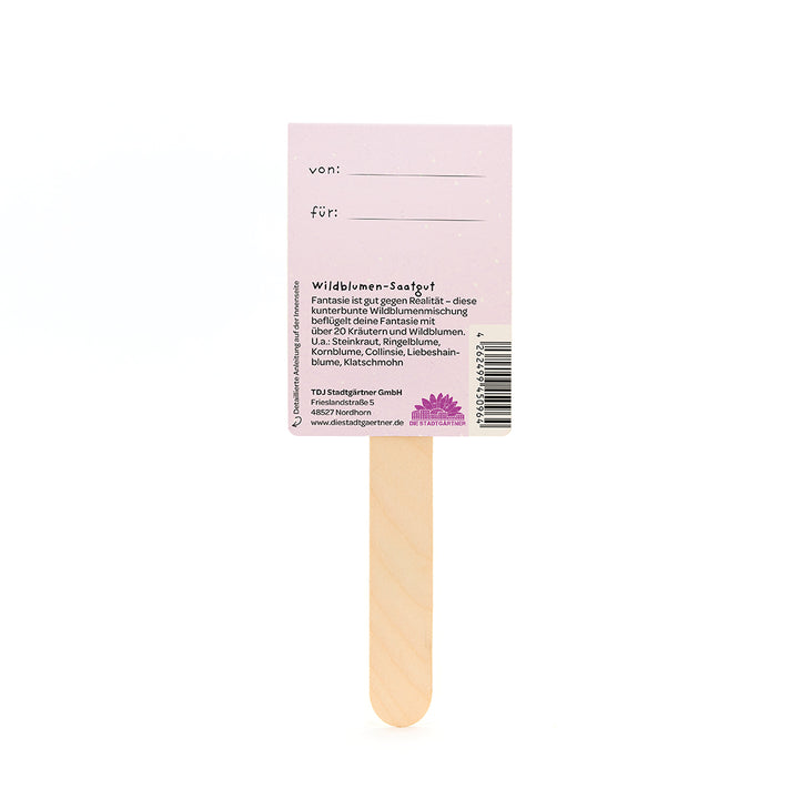 Holzstäbchen mit einem rosa Etikett, auf dem "von" und "für" steht sowie Informationen über Wildblumen-Saatgut auf Deutsch.