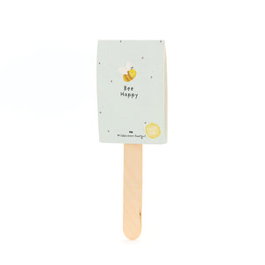 Holzstab mit hellblauem Etikett, darauf eine gezeichnete Biene und der Text "Bee Happy"; Wildblumen-Saatgut.