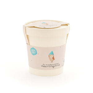 Beiger Becher mit Deckel und Etikett, darauf eine Eule mit blauem Hut und der Aufschrift „Du wunderschönes Geburtstagskind“.