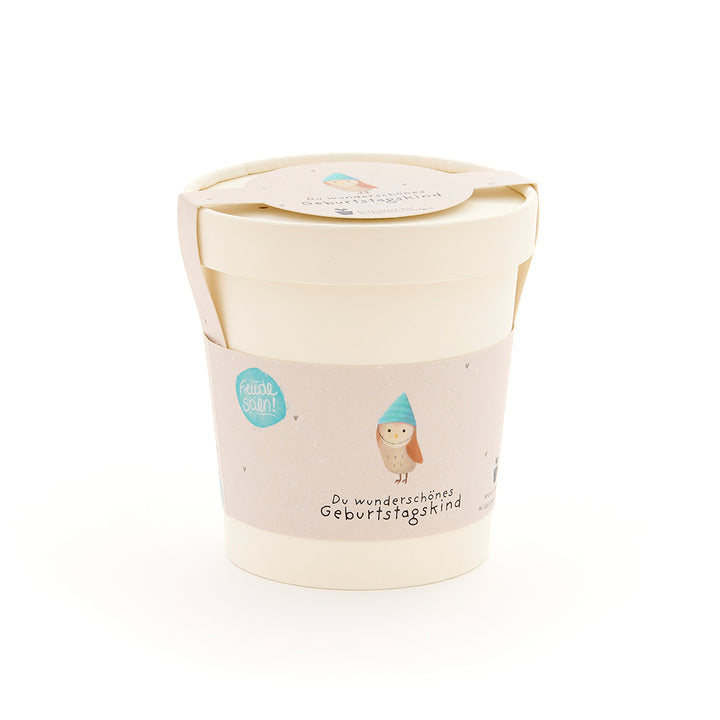 Beiger Becher mit Deckel und Etikett, darauf eine Eule mit blauem Hut und der Aufschrift „Du wunderschönes Geburtstagskind“.