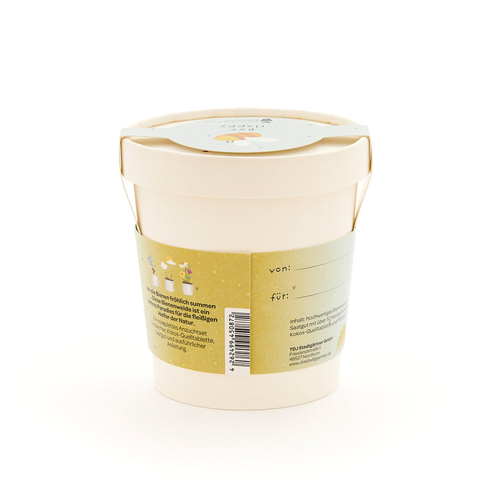 Beiger Blumentopf mit grünem Etikett, auf dem Text und kleine Illustrationen von Blumen und Bienen zu sehen sind.