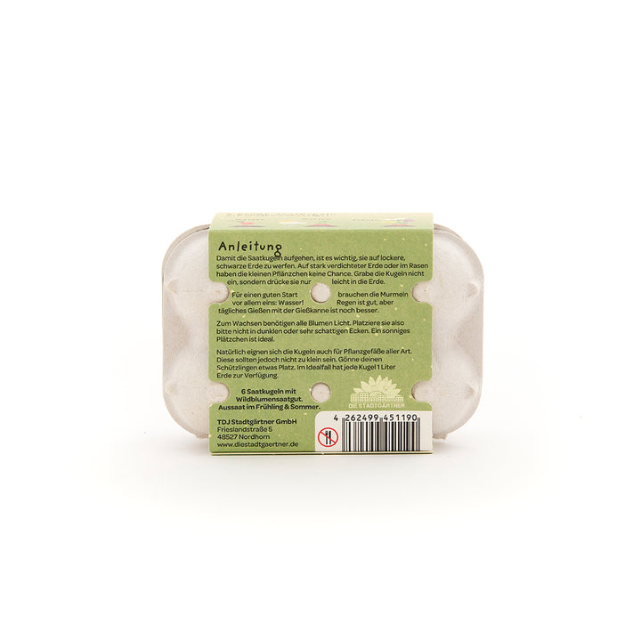 Rückseite einer Verpackung mit einer grünen Anleitung für die Verwendung von Saatkugeln, darunter ein Barcode und Kontaktdaten des Herstellers.