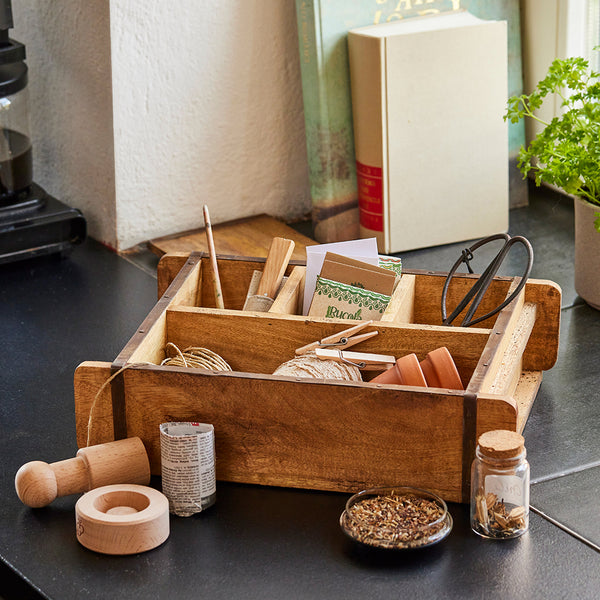 Bakvorm met 4 vakken gevuld met tuingereedschap.