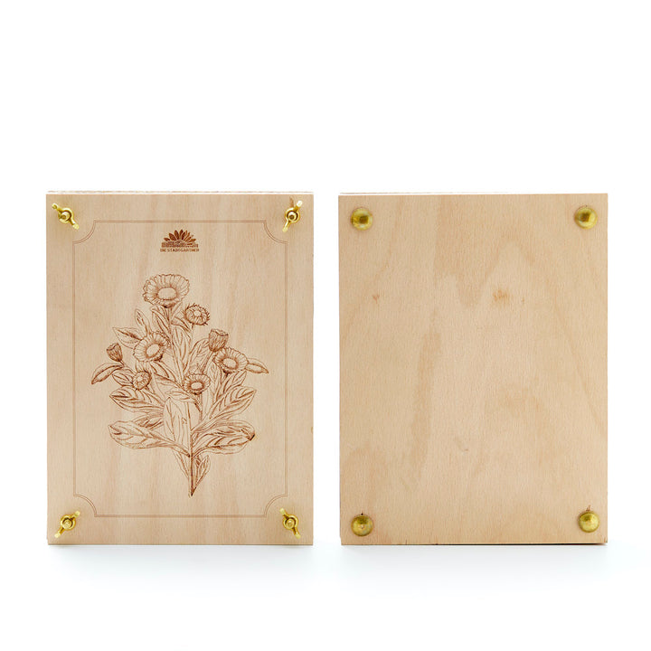 Zwei Holzplatten, eine mit floraler Gravur und Messingschrauben, die andere unverziert.