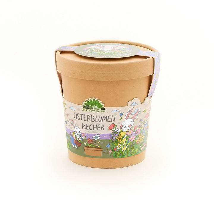 Brauner Blumentopf mit bunter Osterdekoration und der Aufschrift „Osterblumen Becher“, illustriert mit Blumen und einem Hasen.
