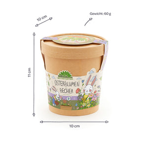 Brauner Becher mit Deckel, buntem Osterhasenmotiv und der Aufschrift „Osterblumen Becher“, daneben Maße (10 cm Durchmesser, 11 cm Höhe) und Gewicht (60 g) angegeben.