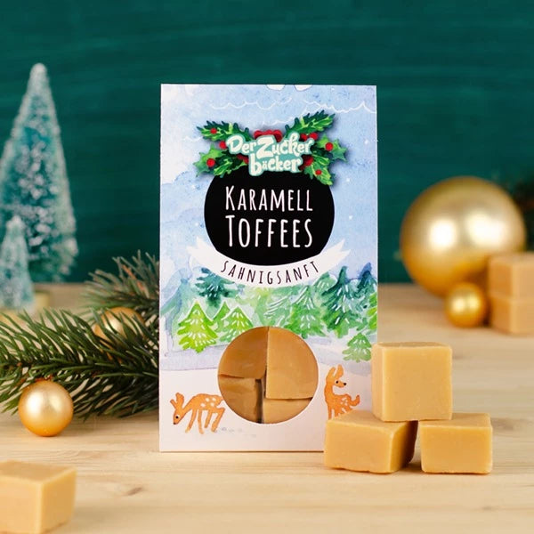 Packung Karamell-Toffees mit weihnachtlicher Dekoration und Tannenzweig.