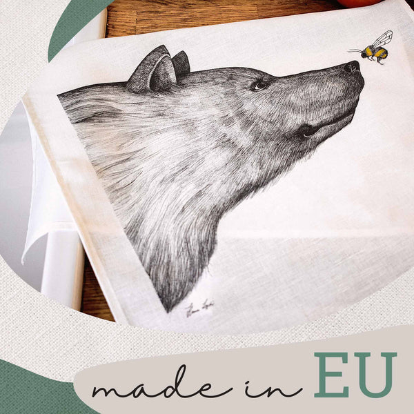 Zeichnung eines Wolfkopfes auf Stoff mit einer fliegenden Biene und dem Schriftzug "made in EU".