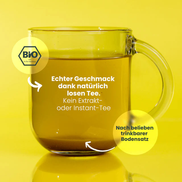 Glastasse mit Bio-Tee und Text zu natürlichen Inhaltsstoffen vor gelbem Hintergrund.
