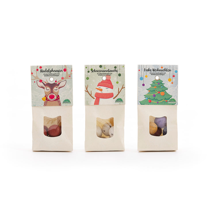 Drei Weihnachtstüten mit Süßigkeiten, verziert mit Illustrationen eines Rentiers, eines Schneemanns und eines Weihnachtsbaums.