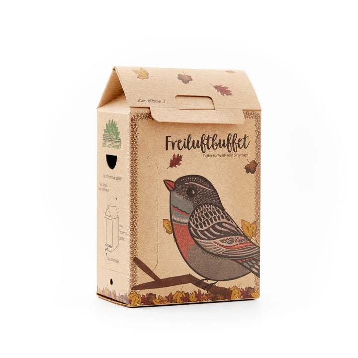 Kraftpapier-Vogelfutterverpackung mit dem Text "Freiluftbüffet" und illustriertem Vogel, umgeben von Herbstlaub.